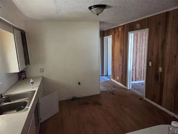 a kitchen with a sink dishwasher a stove and white countertops with wooden floor