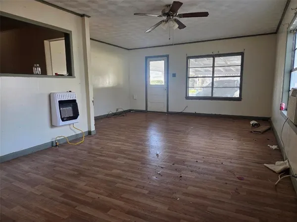 a view of an empty room with a window and wooden floor