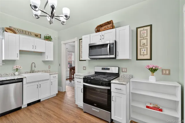 a kitchen with stainless steel appliances sink cabinets and wooden floor