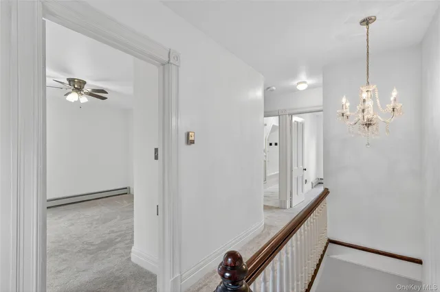 a view of a hallway with chandelier and entryway