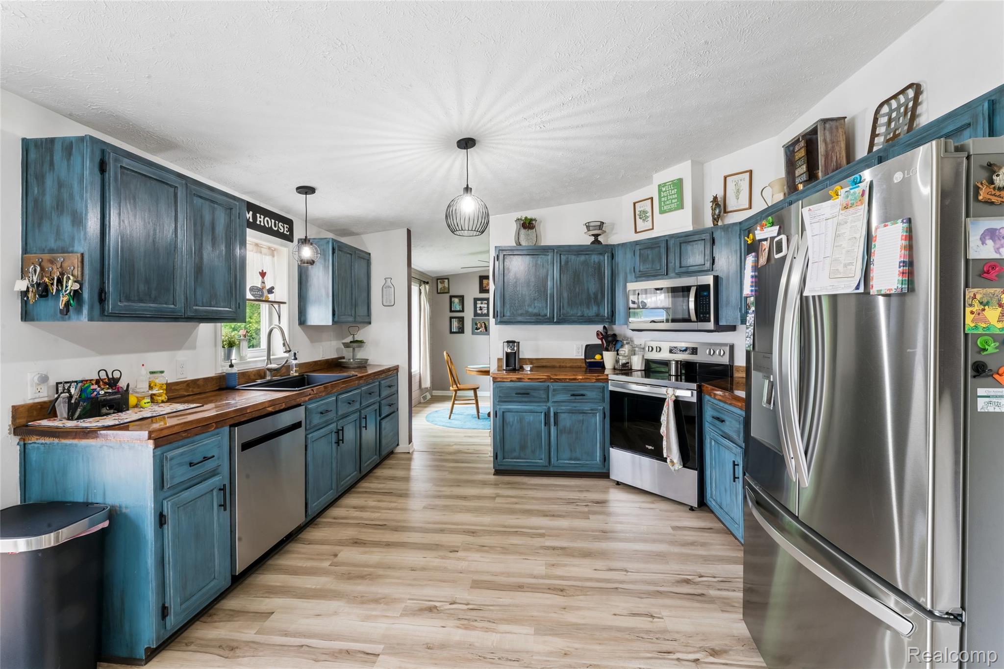 1336 West Hurd Road Clio, MI 48420 - Photo 14 of 43 Spacious kitchen featuring extensive blue cabinetry, wood-finish countertops, and stainless steel appliances including a refrigerator, stove, and dishwasher