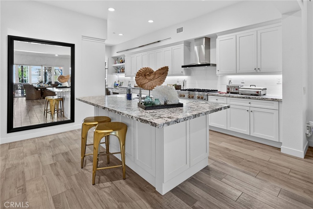 3446 Doheny Way Dana Point, CA 92629 - Photo 22 of 58 a kitchen with stainless steel appliances granite countertop wooden floors and cabinets