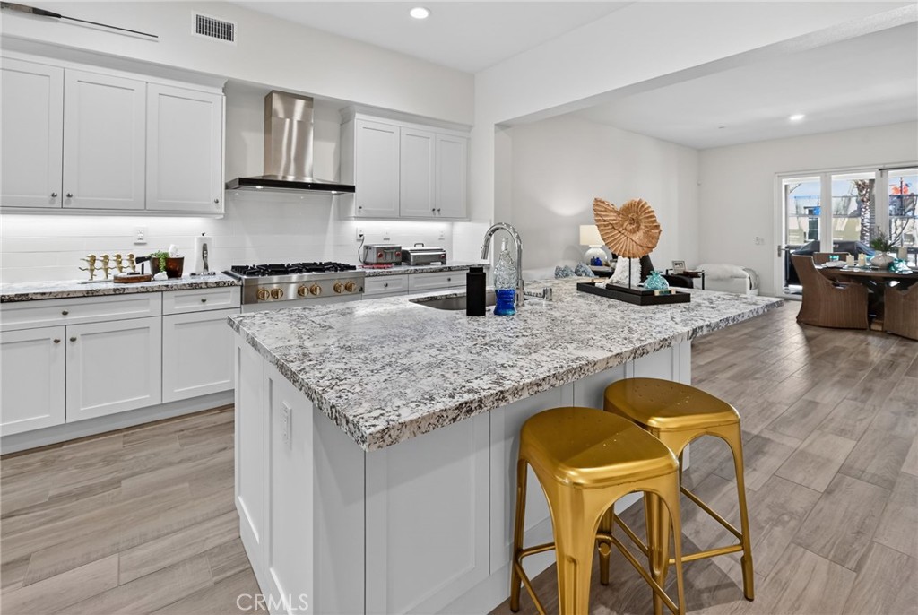 3446 Doheny Way Dana Point, CA 92629 - Photo 24 of 58 a kitchen with kitchen island granite countertop wooden cabinets granite counter tops and a stove