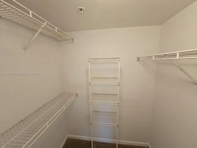 a view of walk in closet with empty racks