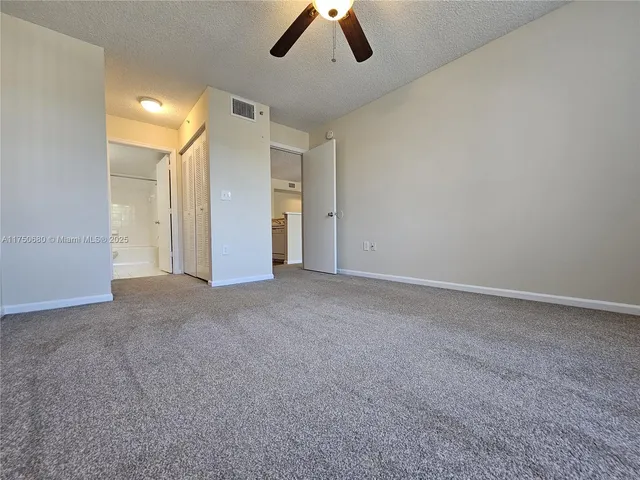 an empty room with ceiling fan and window