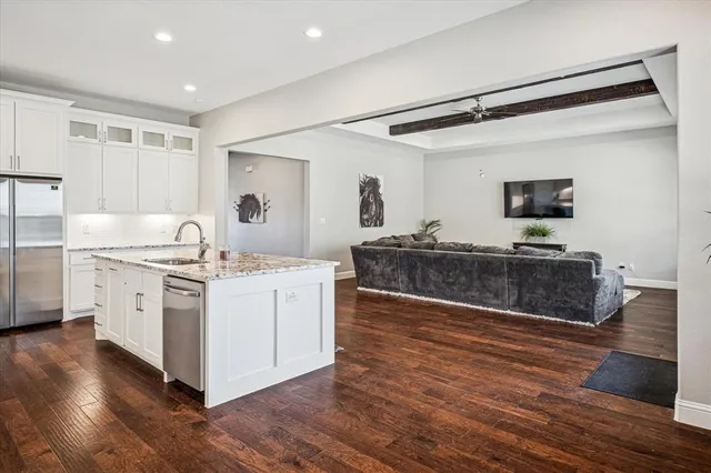 a kitchen with stainless steel appliances white cabinets a sink and a stove