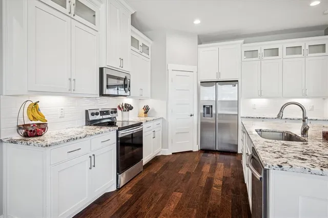 a kitchen with stainless steel appliances granite countertop a stove a sink and a refrigerator