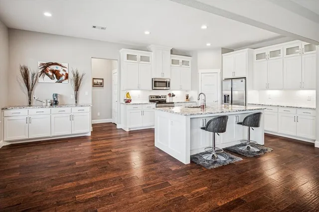 a kitchen with a sink cabinets and wooden floor