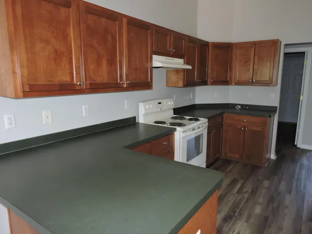 a kitchen with stainless steel appliances granite countertop a stove a sink and a microwave