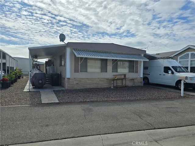 a view of a house with a barbeque grill and couches