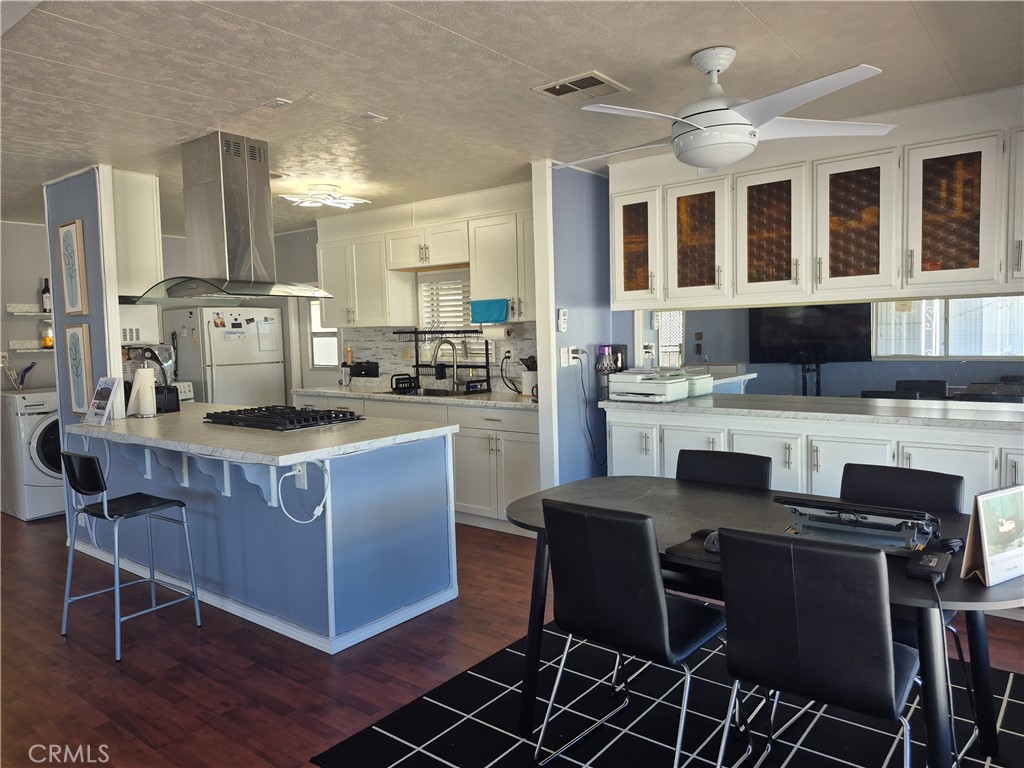 22 Magnolia Via Anaheim, CA 92801 - Photo 26 of 30 a kitchen with stainless steel appliances kitchen island granite countertop a table chairs and a refrigerator