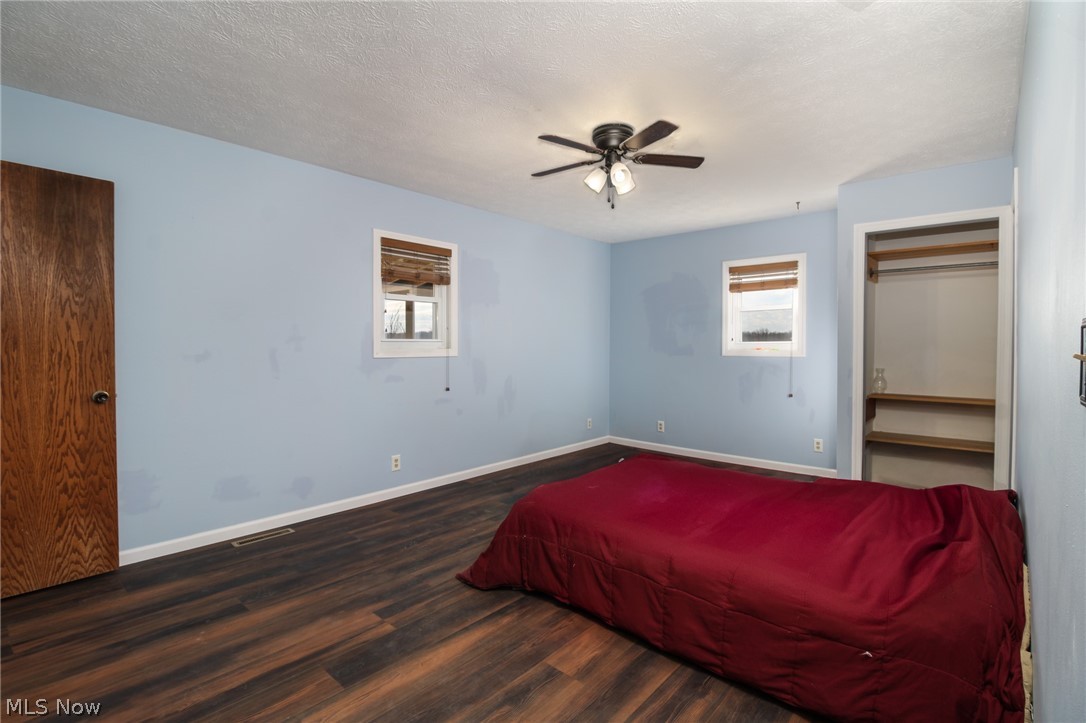 1502 Stone Quarry Road Fleming, OH 45729 - Photo 14 of 31 Primary bedroom with ceiling fan, a textured ceiling, and dark wood-type flooring