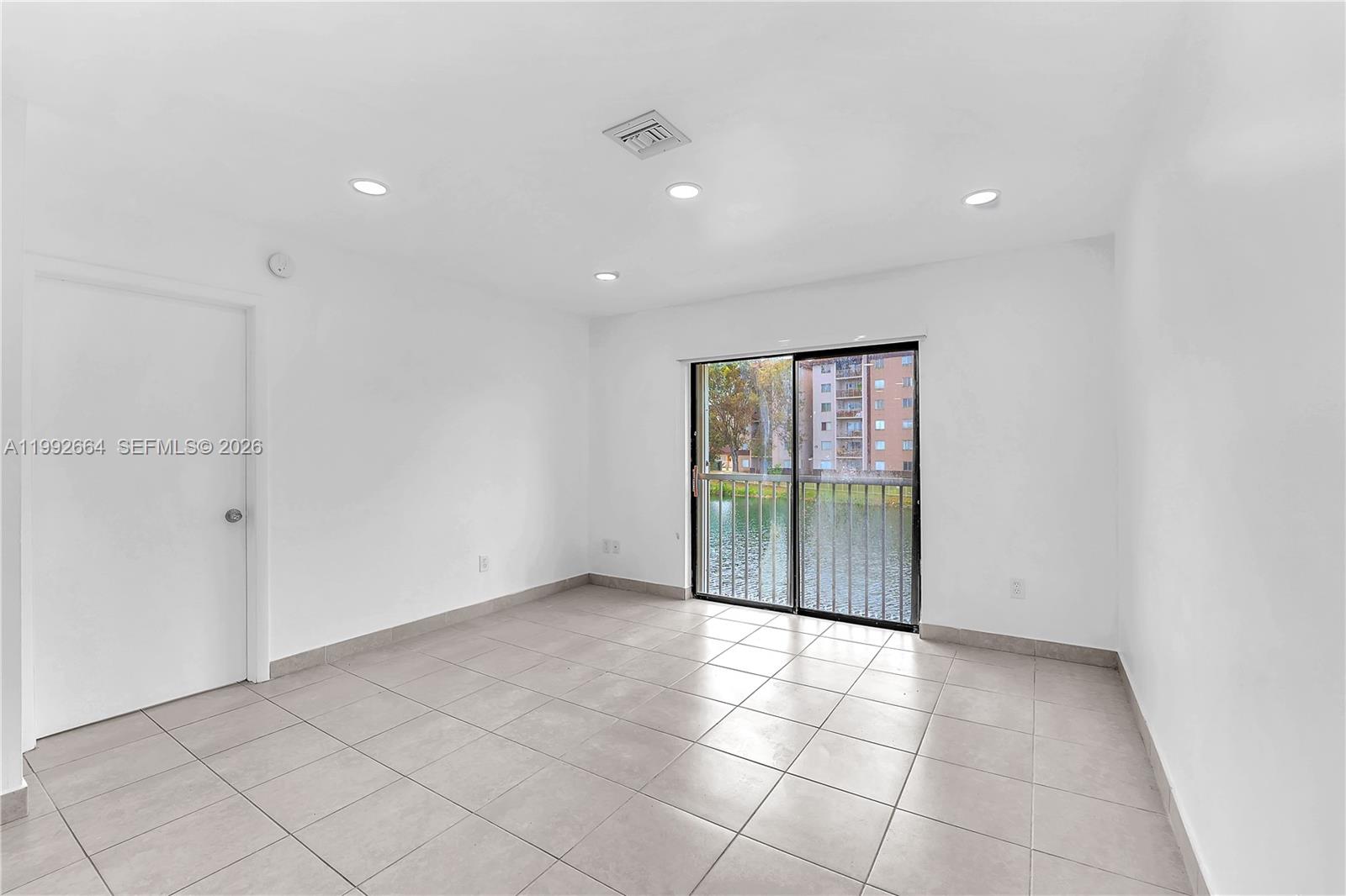 7668 Southwest 152nd Avenue, Unit 2211 Miami, FL 33193 - Photo 12 of 20 a view of an empty room with glass door