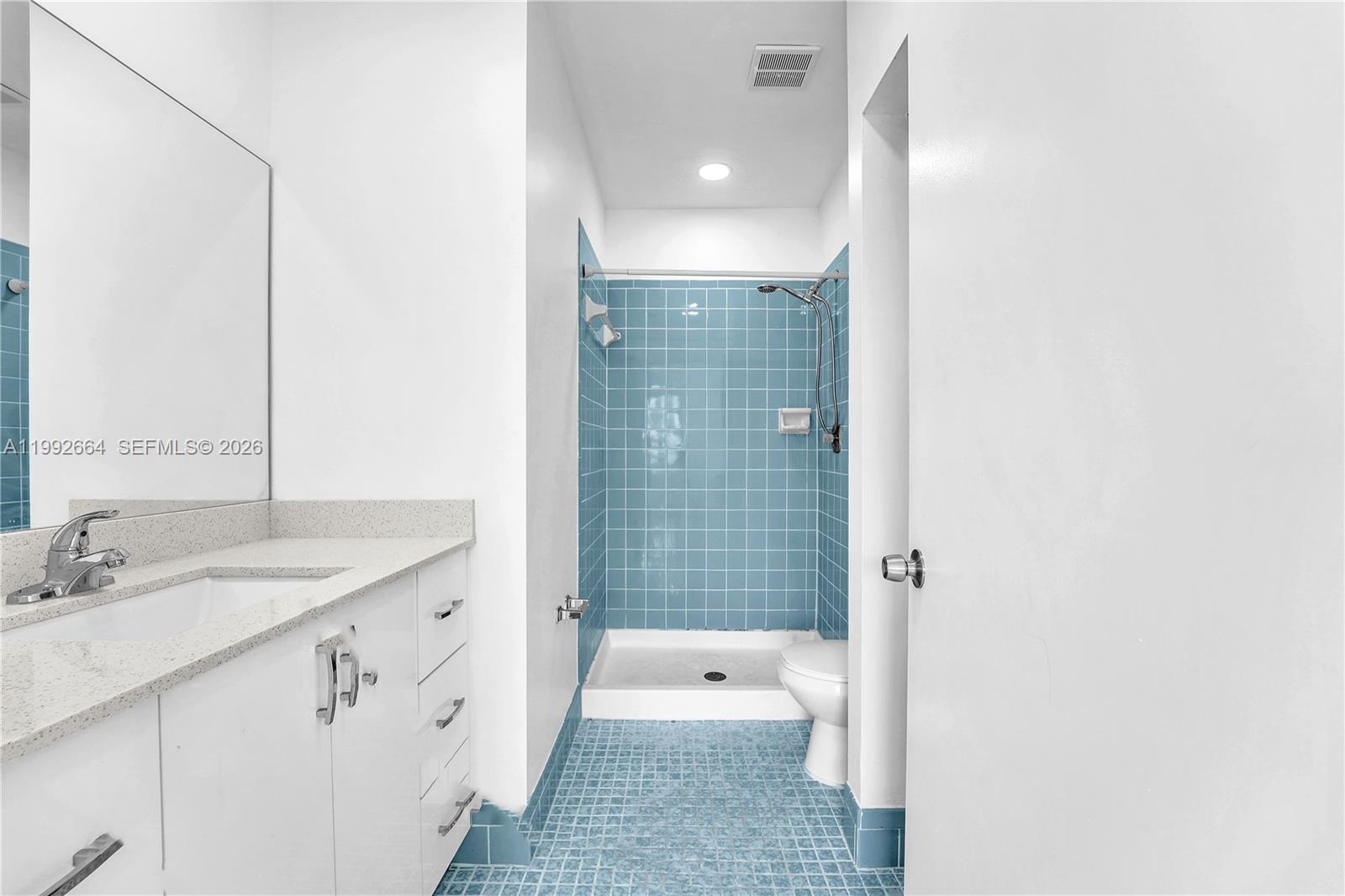7668 Southwest 152nd Avenue, Unit 2211 Miami, FL 33193 - Photo 17 of 20 a bathroom with a granite countertop sink a toilet and shower