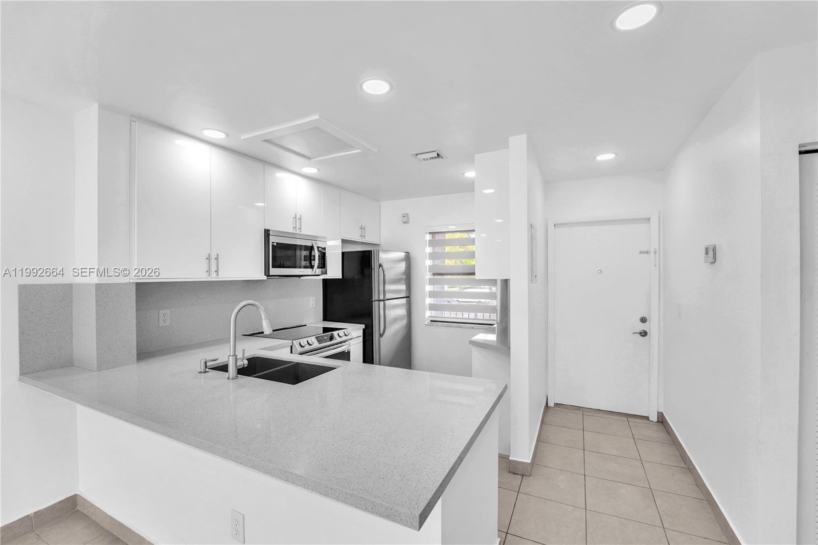 7668 Southwest 152nd Avenue, Unit 2211 Miami, FL 33193 - Photo 6 of 20 a kitchen with stainless steel appliances a refrigerator sink and microwave