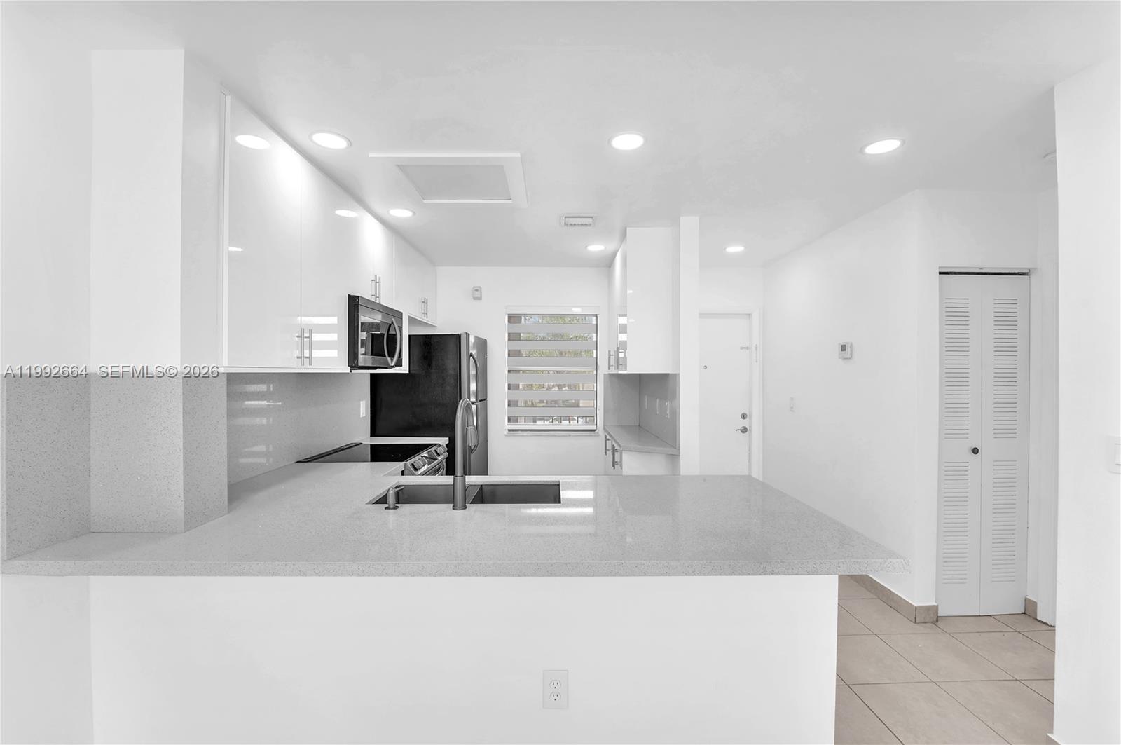 7668 Southwest 152nd Avenue, Unit 2211 Miami, FL 33193 - Photo 7 of 20 a view of a living room with kitchen island sink and refrigerator