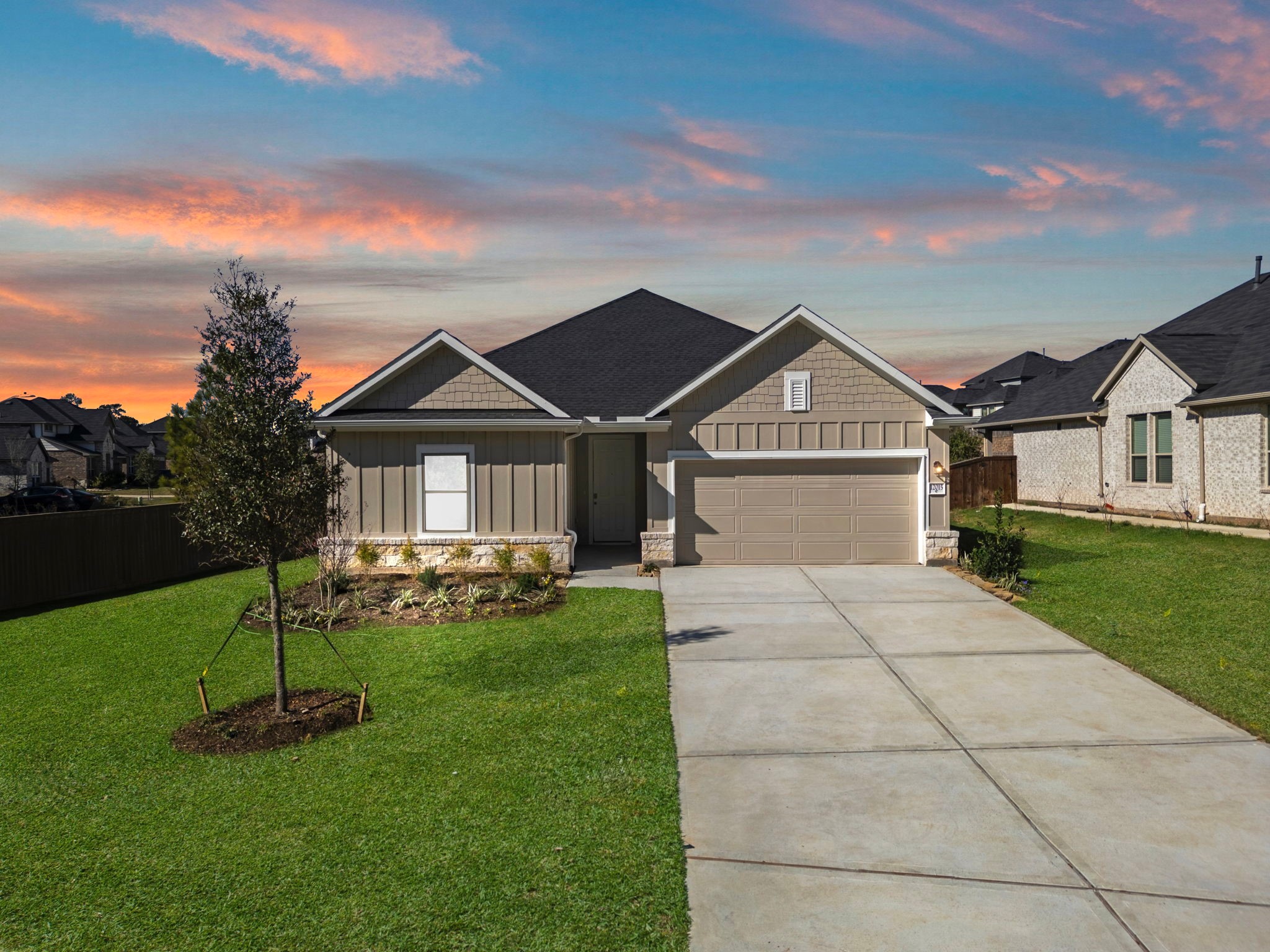 a front view of a house with a garden and trees