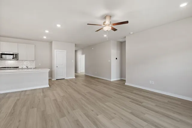 a view of a kitchen with wooden floor and window