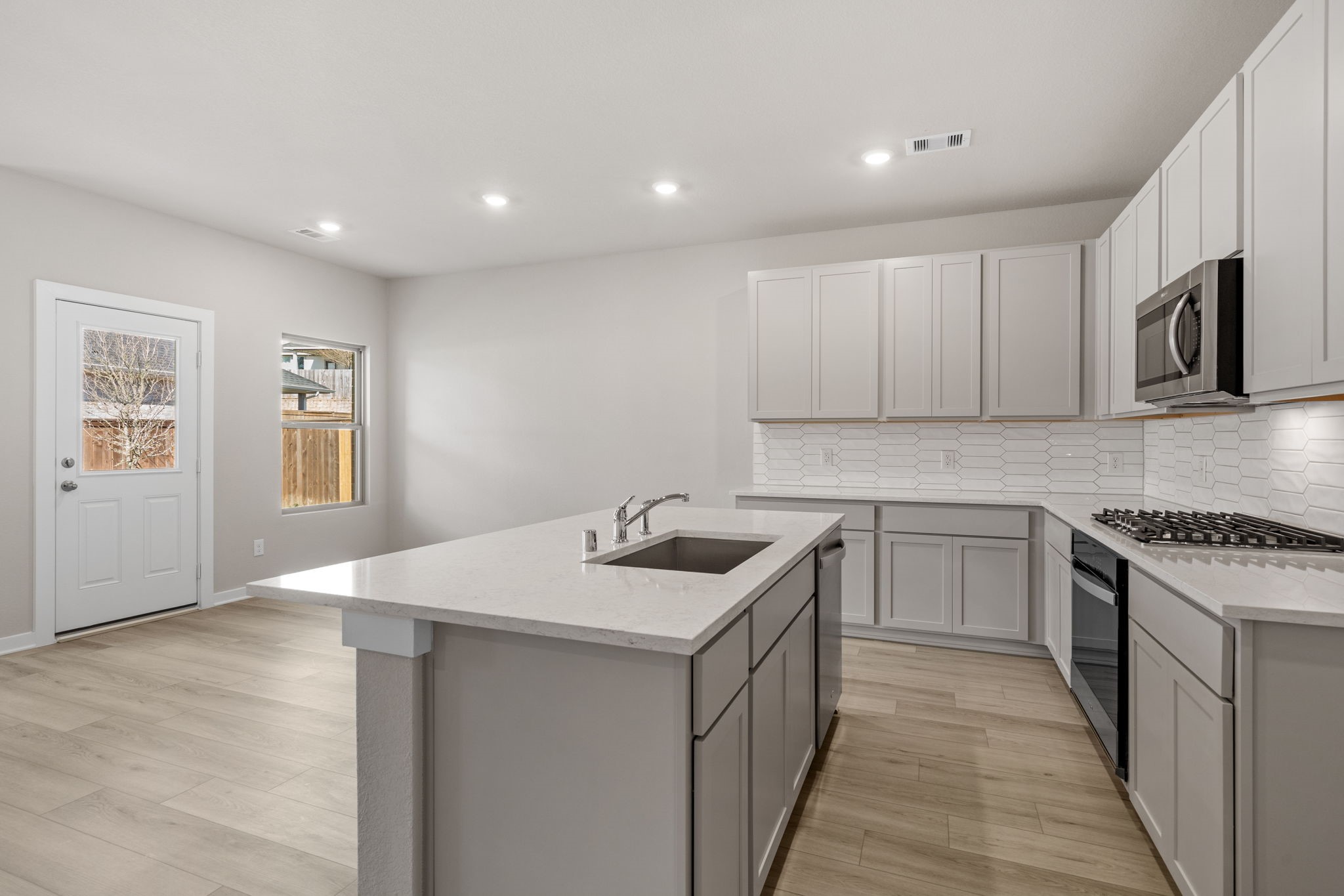 12015 Moonlight Path Drive Conroe, TX 77304 - Photo 5 of 31 a kitchen with kitchen island granite countertop a sink and stove top oven