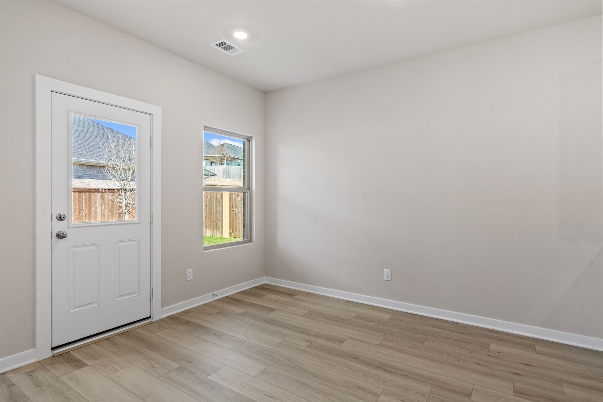 12015 Moonlight Path Drive Conroe, TX 77304 - Photo 9 of 31 an empty room with wooden floor and windows