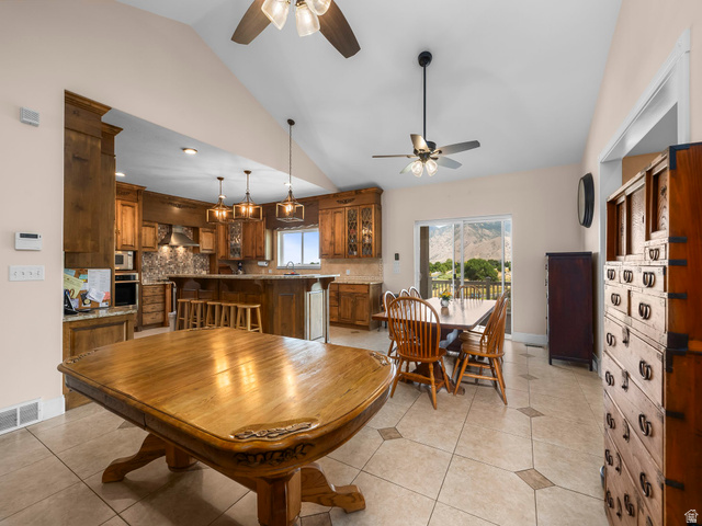 1317 South Pond Circle Mapleton, UT 84664 - Photo 11 of 63 Spacious open concept living area featuring vaulted ceilings with ceiling fans, tile flooring with decorative inserts, and wood-finish cabinetry throughout