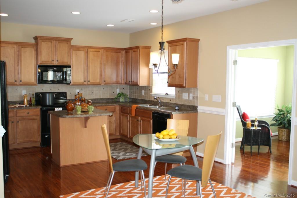6418 Hermsley Road Charlotte, NC 28278 - Photo 3 of 22 a kitchen with stainless steel appliances granite countertop a stove a sink a microwave a dining table and chairs