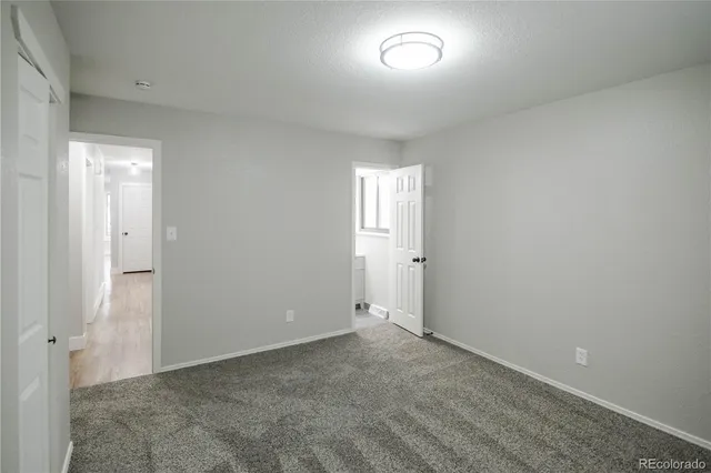 an empty room with windows and closet