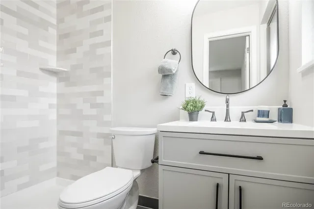 a bathroom with a sink a toilet and a mirror