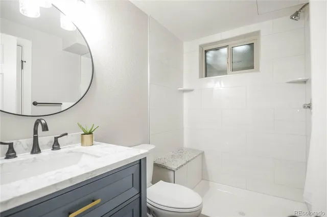 a bathroom with a sink a toilet and mirror