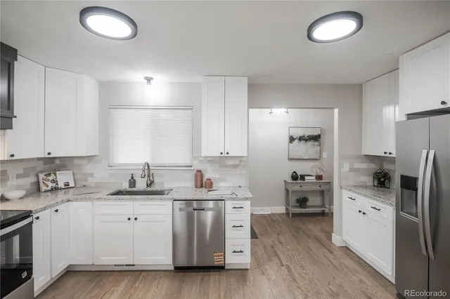 a kitchen with stainless steel appliances a sink stove refrigerator and cabinets