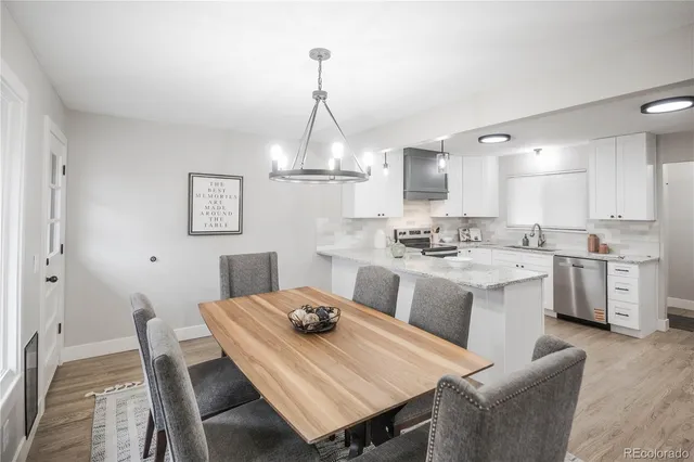 a kitchen with a dining table chairs and white cabinets