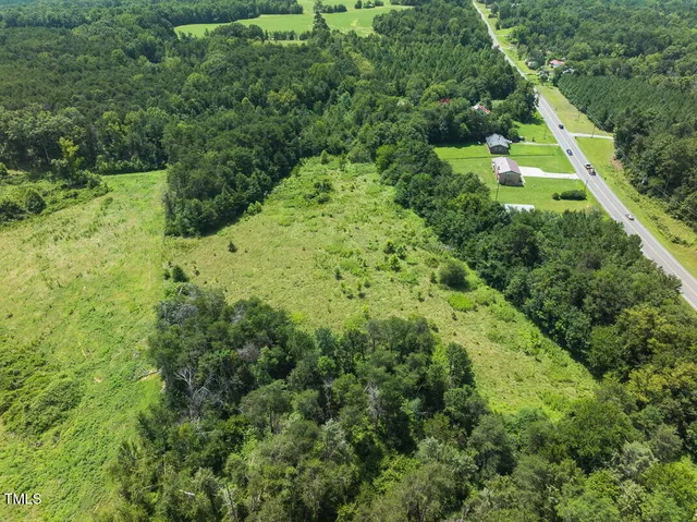 an aerial view of residential house with outdoor space and trees all around