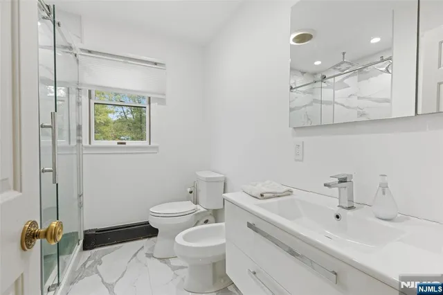 a bathroom with a sink mirror vanity and toilet