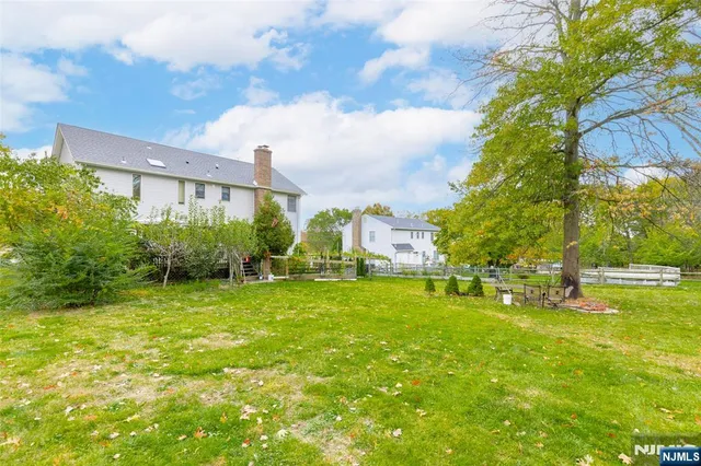 a view of a house with a big yard and a large tree