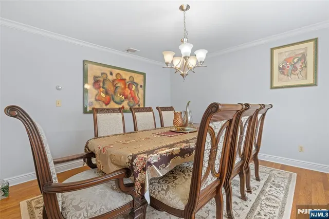 a view of a dining room with furniture a chandelier and wooden floor