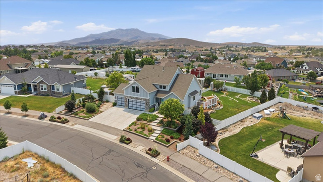 2038 East Ranch Road Eagle Mountain, UT 84005 - Photo 57 of 66 Contemporary home featuring a dual-tone exterior, attached three-car garage, mature landscaping, expansive backyard, and a mountain backdrop
