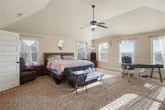 a spacious bedroom with a bed a table and chairs