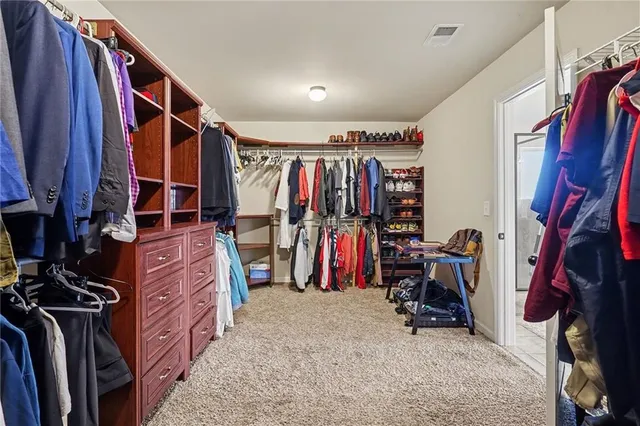 a view of walk in closet with clothes