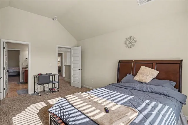 a bedroom with a large bed and a chair