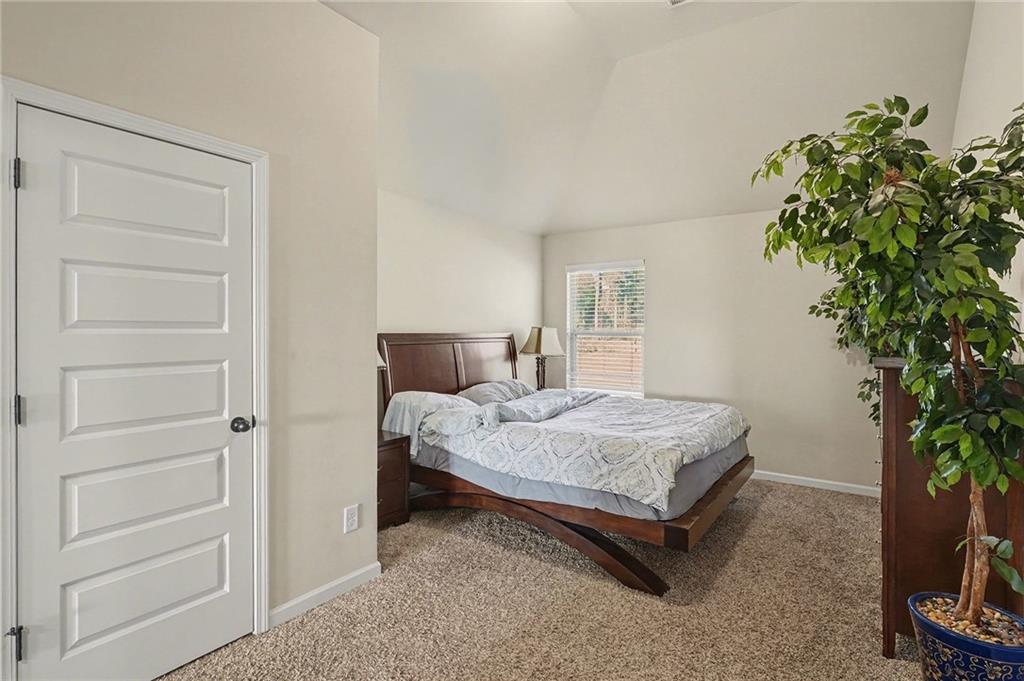 560 Aerial Avenue Stockbridge, GA 30281 - Photo 28 of 35 a bed sitting in a spacious bedroom next to a window and a potted plant