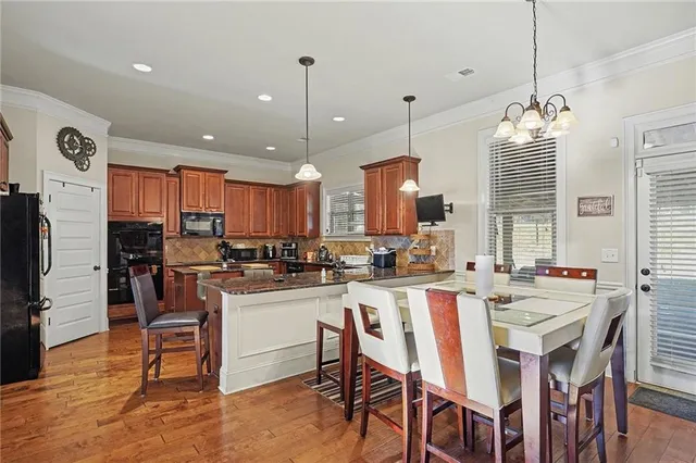 a kitchen with a dining table chairs sink refrigerator and fireplace