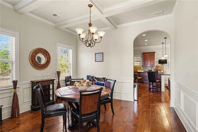 a view of a dining room with furniture a chandelier and wooden floor