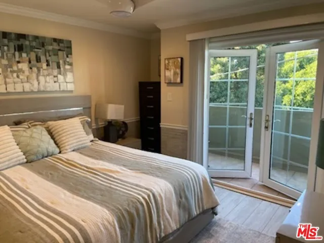 a large bed sitting in a bedroom next to a window