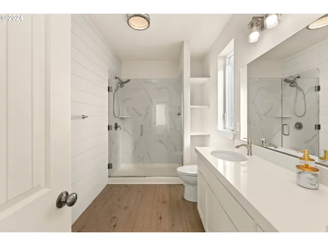 a bathroom with a sink a toilet a shower and a mirror