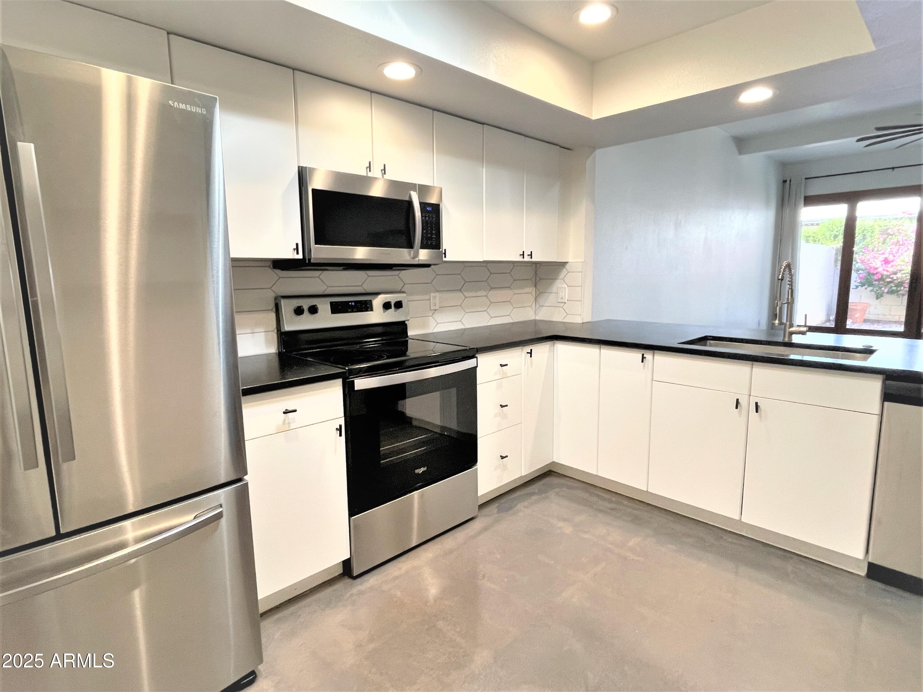 8 West Griswold Road Phoenix, AZ 85021 - Photo 7 of 22 a kitchen with granite countertop white cabinets and stainless steel appliances