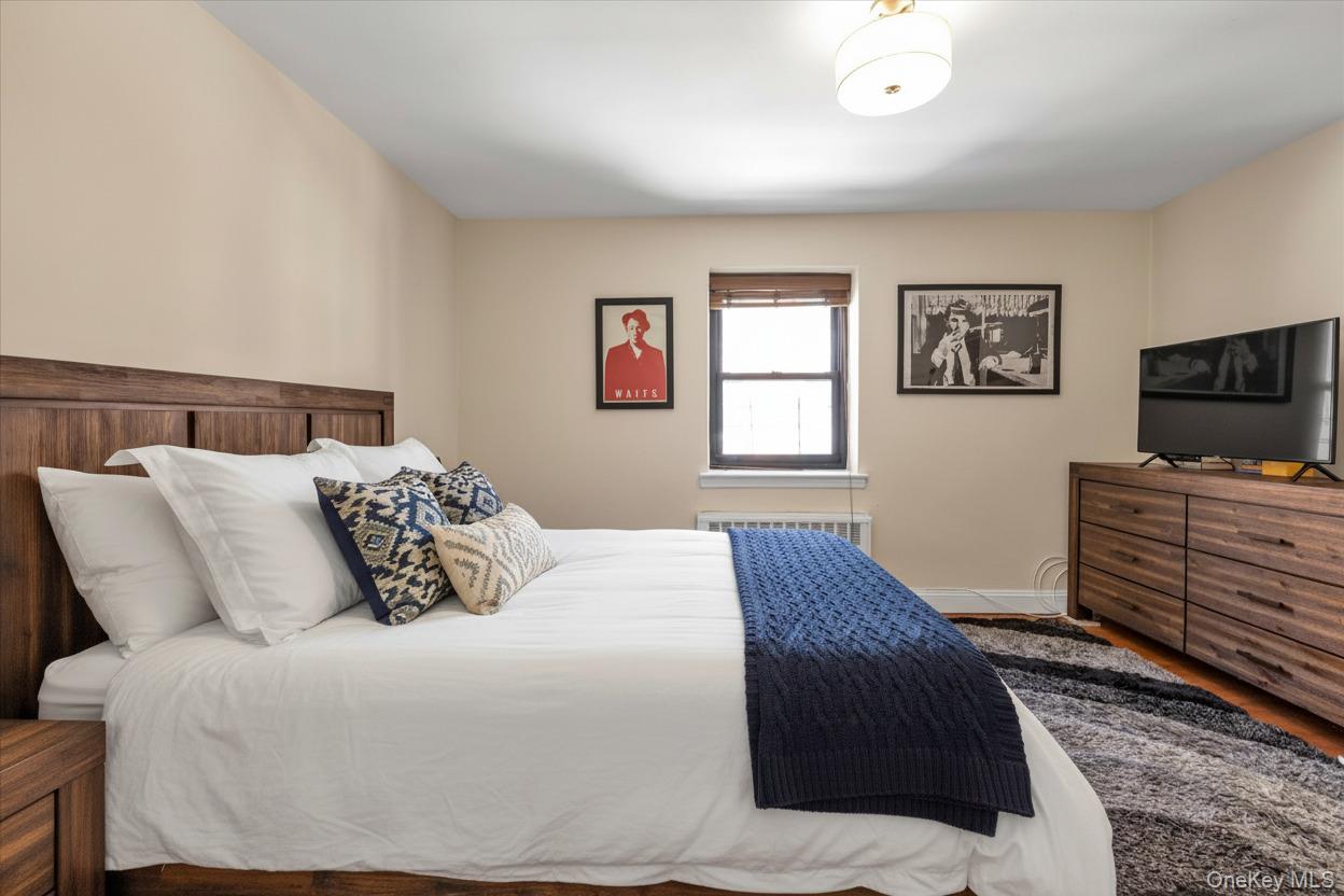 102-25 67th Road, Unit 4C Queens, NY 11375 - Photo 11 of 16 a bedroom with a bed and flat screen tv