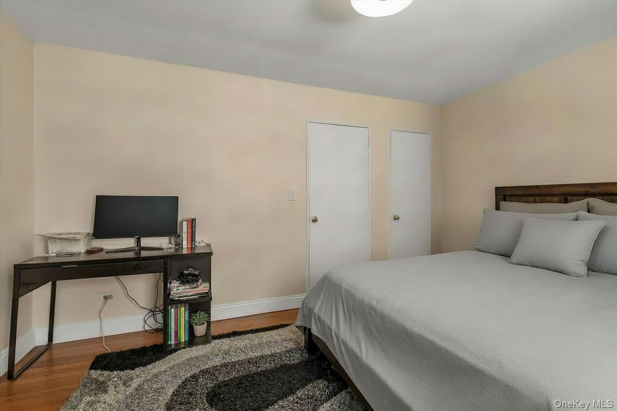 102-25 67th Road, Unit 4C Queens, NY 11375 - Photo 12 of 16 a bedroom with a bed and a computer on a table