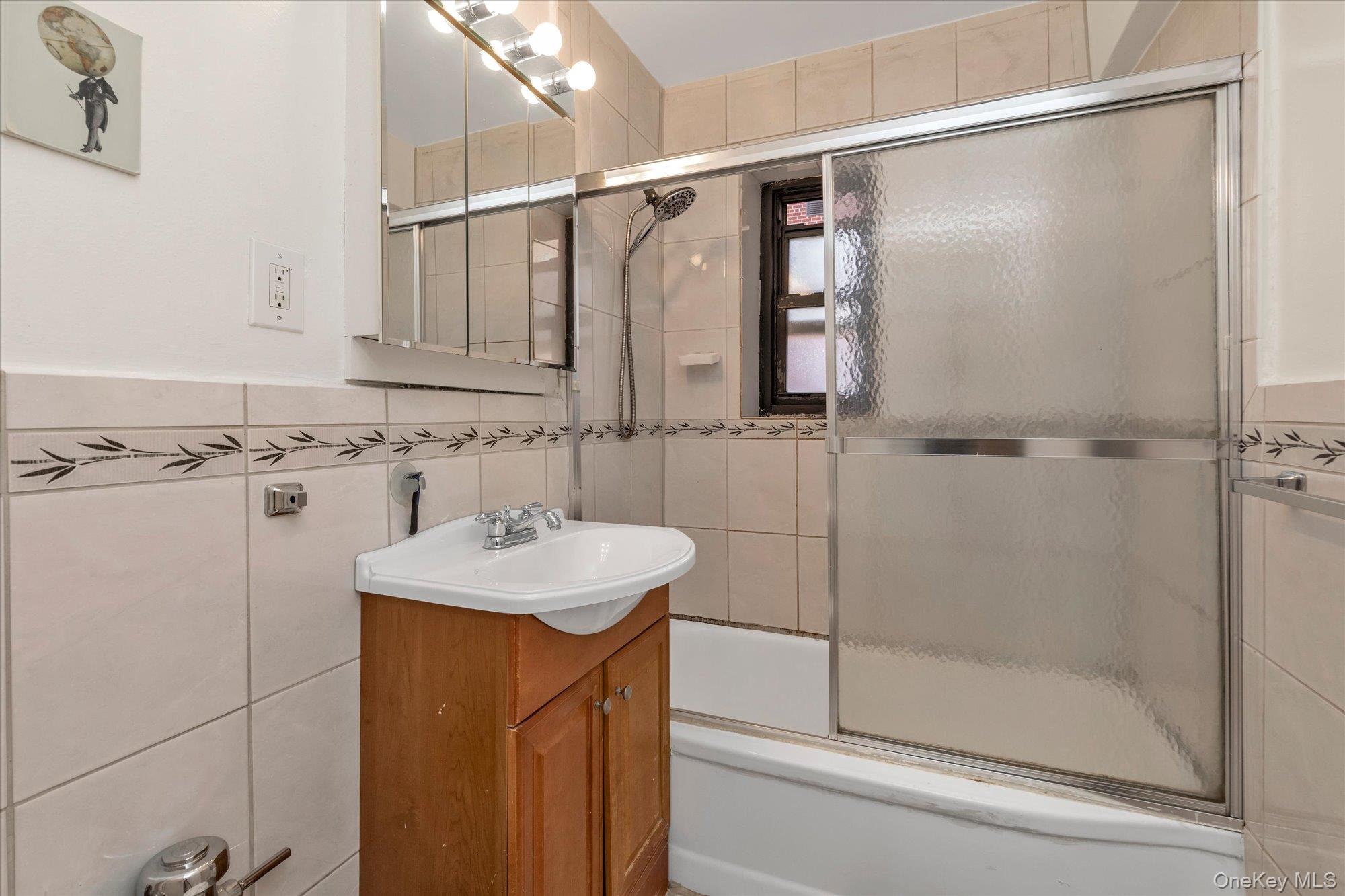 102-25 67th Road, Unit 4C Queens, NY 11375 - Photo 13 of 16 a bathroom with a sink a shower and a mirror