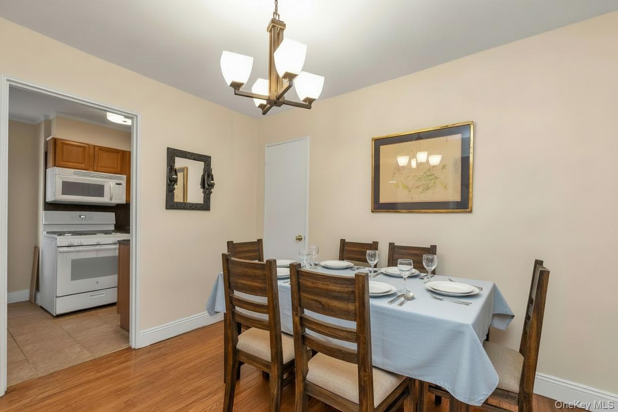 102-25 67th Road, Unit 4C Queens, NY 11375 - Photo 6 of 16 a view of a dining room with furniture wooden floor and a chandelier