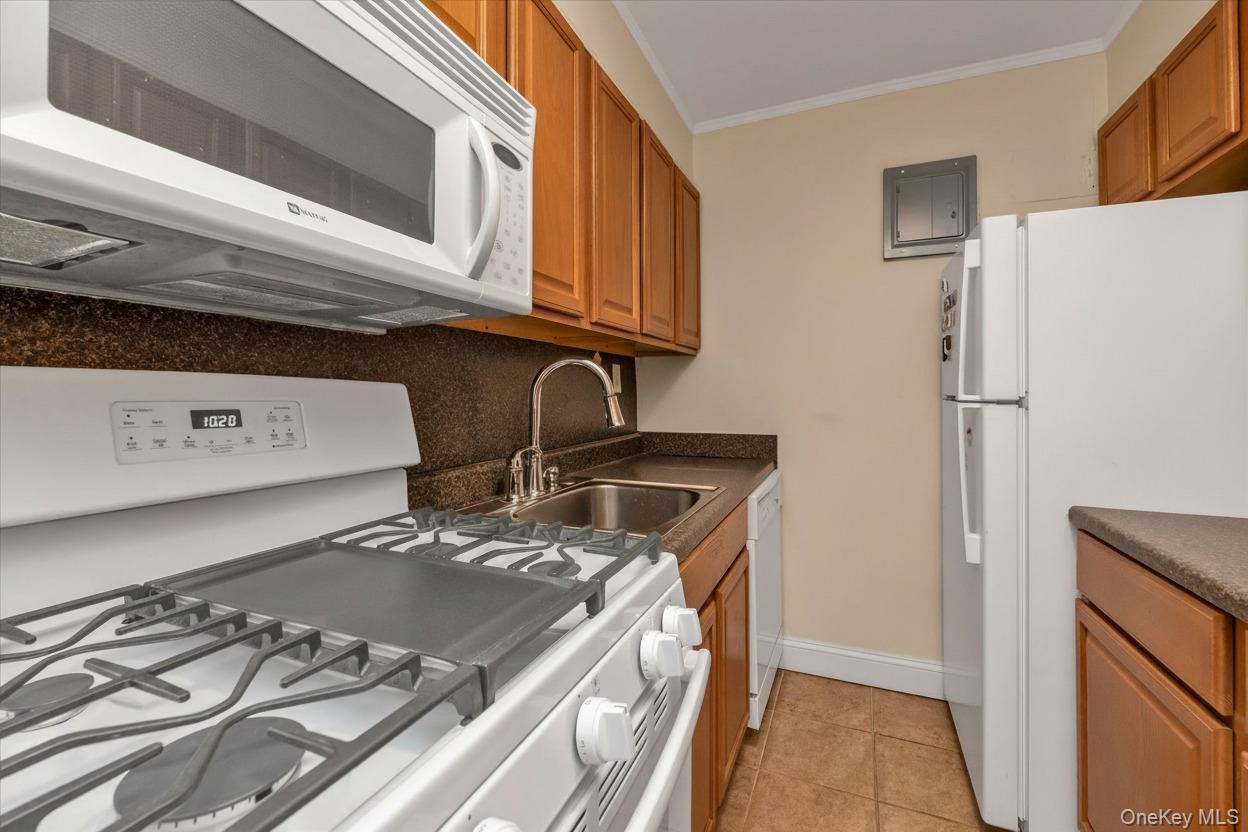 102-25 67th Road, Unit 4C Queens, NY 11375 - Photo 8 of 16 a kitchen with a stove and a refrigerator